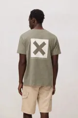 Remera de manga corta color blanco con cuello redondo y pequeño estampado cuadrado en el pecho con una cruz en color verde claro.