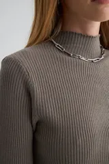 Polera de tejido de punto acanalado en color gris oscuro, con cuello alto y mangas largas ajustadas.