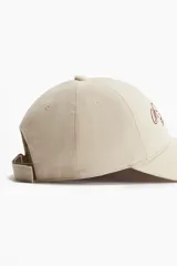 Gorra de sarga de algodón con efecto lavado, visera curva y bordado frontal con texto. Cuenta con trabilla ajustable con cierre de metal en la parte posterior.