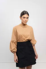 Minifalda negra de velvetine con spandex y bolsillos frontales.