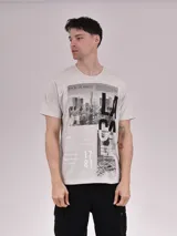Remera de manga corta color beige melange, de corte clásico con cuello redondo. Presenta un estampado frontal fotográfico en tonos blanco y negro con la inscripción "CITY OF LOS ANGELES" y gráficos tipográficos grandes.