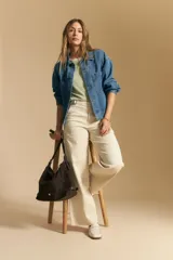 Top tejido sin mangas color negro, con cuello redondo y volados en las sisas con terminación en contraste de punto blanco. Presenta un calce recto y puño inferior acanalado con detalle de punto blanco.