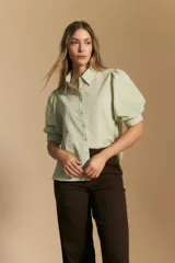 Camisa de manga larga color verde menta, con cuello camisero y botones frontales. Presenta mangas abullonadas con puños ajustados.