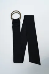 Cinturón de gamuza negra con hebilla de doble argolla metálica en tono bronce.