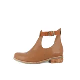 Botín de cuero color beige con abertura lateral y correa con hebilla alrededor del tobillo.