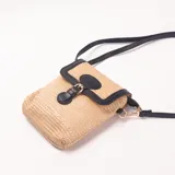 Cartera bandolera de rafia color beige con detalles en cuero sintético negro. Tiene solapa con cierre de broche y correa ajustable.