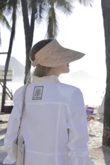 Chaqueta de lino marrón con cuello mao en contraste negro, cierre frontal con botones y hombreras.