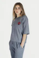 Remera de corte suelto y mangas cortas, color gris con efecto lavado. Presenta un parche circular con estampado en el pecho.