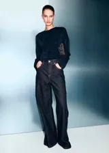 Top de manga larga en color negro, con diseño recto y cuello drapeado. Confeccionado en tejido fluido con acabado ligeramente satinado.