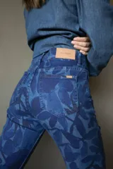 Pantalón de jean de corte recto con estampado de hojas en tonos azules.