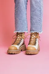 Botas de cuero color blanco, marrón y beige, con cordones y suela track.