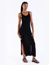 Vestido largo negro de punto jersey con hilo lurex, escote bote redondeado, sin mangas y aberturas laterales.