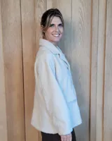Sobrecamisa de paño color beige, con cuello solapa, cierre frontal de botones y dos bolsillos delanteros con solapa.