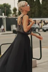 Vestido midi de gabardina en color negro, con cuello halter, tirantes finos y falda con vuelo. Cuenta con cierre en la espalda con cremallera oculta.