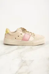 Zapatilla urbana de cuero color beige con detalles en rosa y amarillo.