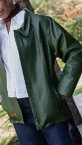 Campera de cuero color verde, con cierre frontal, cuello clásico y mangas largas. Presenta un diseño minimalista con un pequeño parche de cuero en el ruedo.