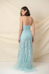 Vestido largo de fiesta color celeste agua marina, de tul bordado con flores. Diseño strapless, corte sirena y cola. Incluye chaqueta corta tipo torera de tul bordado con mangas largas anchas en los puños.