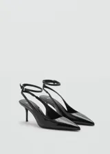 Zapato tipo slingback de tacón de aguja, con acabado efecto charol, punta fina y cierre de hebilla ajustable al tobillo.