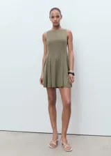 Vestido corto sin mangas de corte evasé, con cuello barco y detalle de pliegues en la falda.