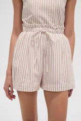 Short de tiro alto con diseño de rayas verticales en tonos beige y blanco. Presenta una cintura elástica con detalle de volado y cordón ajustable para atar al frente. Su corte es holgado y cómodo.
