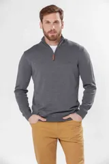 Buzo de tejido fino en hilo de algodón, color rosado, con cuello alto y cierre frontal parcial con detalle en cuero. Presenta puños y ruedo acanalados y un pequeño logo bordado en el pecho.