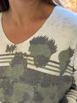 Sweater de punto con cuello en V y mangas largas, de diseño holgado. Presenta un estampado abstracto en tonos verdes con detalles metalizados en color dorado sobre una base de color crema.