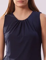 Musculosa negra de poliéster y elastano, con cuello redondo con frunces delanteros y abertura con botón en la espalda.