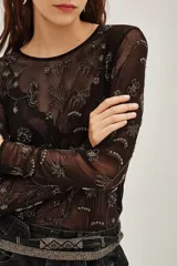 Camisa de mesh transparente con mangas largas y cuello redondo, decorada con bordados de cuentas y lentejuelas en diseño floral.
