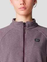 Campera polar de mujer con cierre frontal completo, cuello alto y bolsillos laterales con cierre. Confeccionada en tejido de vellón de poliéster reciclado, presenta un diseño de manga raglán para mayor movilidad y logo bordado en el pecho.