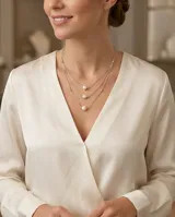 Collar de tres niveles elaborado en plata 925, con una perla de río central en cada cadena y pequeños detalles esféricos en la estructura.