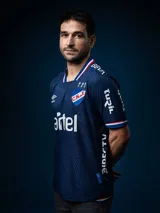 Camiseta de fútbol Umbro del Club Nacional de Football, modelo Away 2025, de color azul con patrón de ondas texturizadas. Cuenta con detalles en blanco, rojo y azul en el cuello y las mangas. Incluye el escudo del club, el logo de Umbro y patrocinadores estampados.