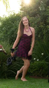 Vestido corto de color bordó con superposición de encaje negro, diseño tipo corset con escote corazón y breteles finos. Presenta un corte ajustado en el torso y falda con volados en el ruedo.