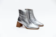 Botas plateadas de cuero con caña media, cierre lateral con cremallera, punta cuadrada y tacón geométrico de madera.