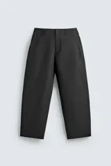 Pantalón de corte balloon fit, color negro, con bolsillos laterales de vivo y bolsillos traseros con solapa. Presenta cierre frontal con cremallera y botón.