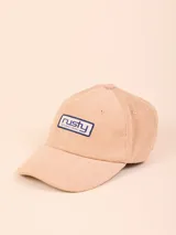 Gorro de pana color beige con visera curva y logo de la marca bordado en el frente.