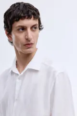 Camisa H&M de lino liviano color blanco, de corte entallado slim fit, con cuello italiano y manga larga.