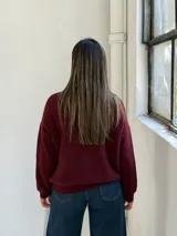 Saco tipo cardigan de punto, color bordó, con escote en V y cierre frontal de botones. Presenta mangas largas con puños acanalados y un diseño de calce holgado.