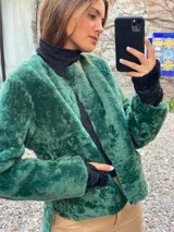 Saco de silueta recta y levemente corto, color verde oscuro. Cuenta con cuello a la base, manga larga y bolsillos laterales discretos.