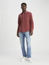 Jeans de mezclilla azul claro con efecto lavado y desgaste sutil. Presentan un corte recto y talle medio, con cierre de cremallera y diseño de cinco bolsillos. Incluyen una etiqueta de cuero con el logo de Calvin Klein en el bolsillo trasero derecho.