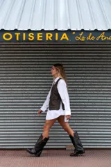 Bota de cuero marrón con diseño 2 en 1, que permite usarla con o sin polaina. Presenta una suela track robusta, cierre lateral y una tira con hebilla metálica en la parte superior de la caña.