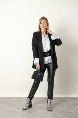 Blazer negro de paño con corte recto, cierre con un botón y dos bolsillos delanteros.