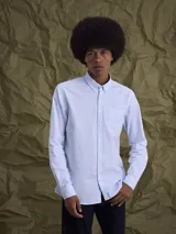 Camisa de manga larga confeccionada en tejido Oxford de algodón, con cuello abotonado (button-down) y bolsillo frontal en el pecho.