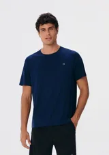 Camiseta deportiva azul marino de manga corta y cuello redondo, con un pequeño logo blanco bordado en el pecho.