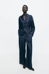 Pantalón de jean estilo wide leg en color azul oscuro, con cintura elástica y cordón ajustable. Presenta costuras verticales decorativas en el frente y bolsillos laterales.