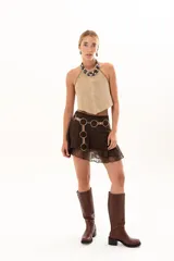 Pollera corta de encaje color chocolate, con diseño de volados y cinturón incorporado de cuero sintético con argollas metálicas.