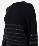 Suéter de punto color negro con cuello redondo y mangas largas. Presenta un diseño con franjas horizontales decoradas con lentejuelas del mismo tono en el cuerpo y las mangas.