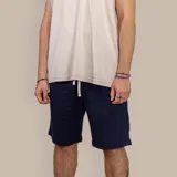 Bermuda deportiva azul marino de algodón, con cintura elástica ajustable con cordón, bolsillos laterales y bolsillo trasero.