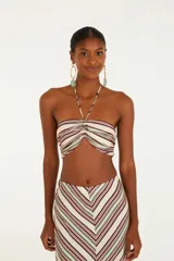 Top de rayas horizontales en tonos crudo, borgoña y verde, con diseño sin tirantes, detalle torcido en el busto y cierre con cordón ajustable.