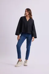 Camisa negra de lino con cuello en V y cierre frontal con botones.