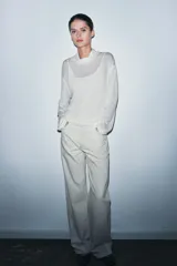 Camiseta blanca de manga larga con cuello alto y calce oversize. Incluye un top interior del mismo tejido.